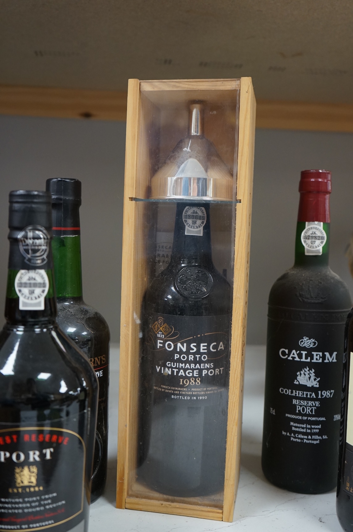 Five assorted bottles of port, including a boxed Fonseca 1988, a bottle of Calem 1987 and three other bottles of port.